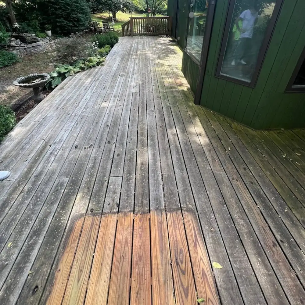Weathered wood deck mid-clean showing restored wood color